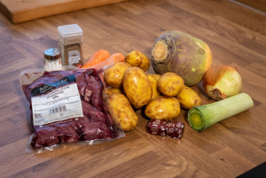 Beef stew ingredients arranged on kitchen surface